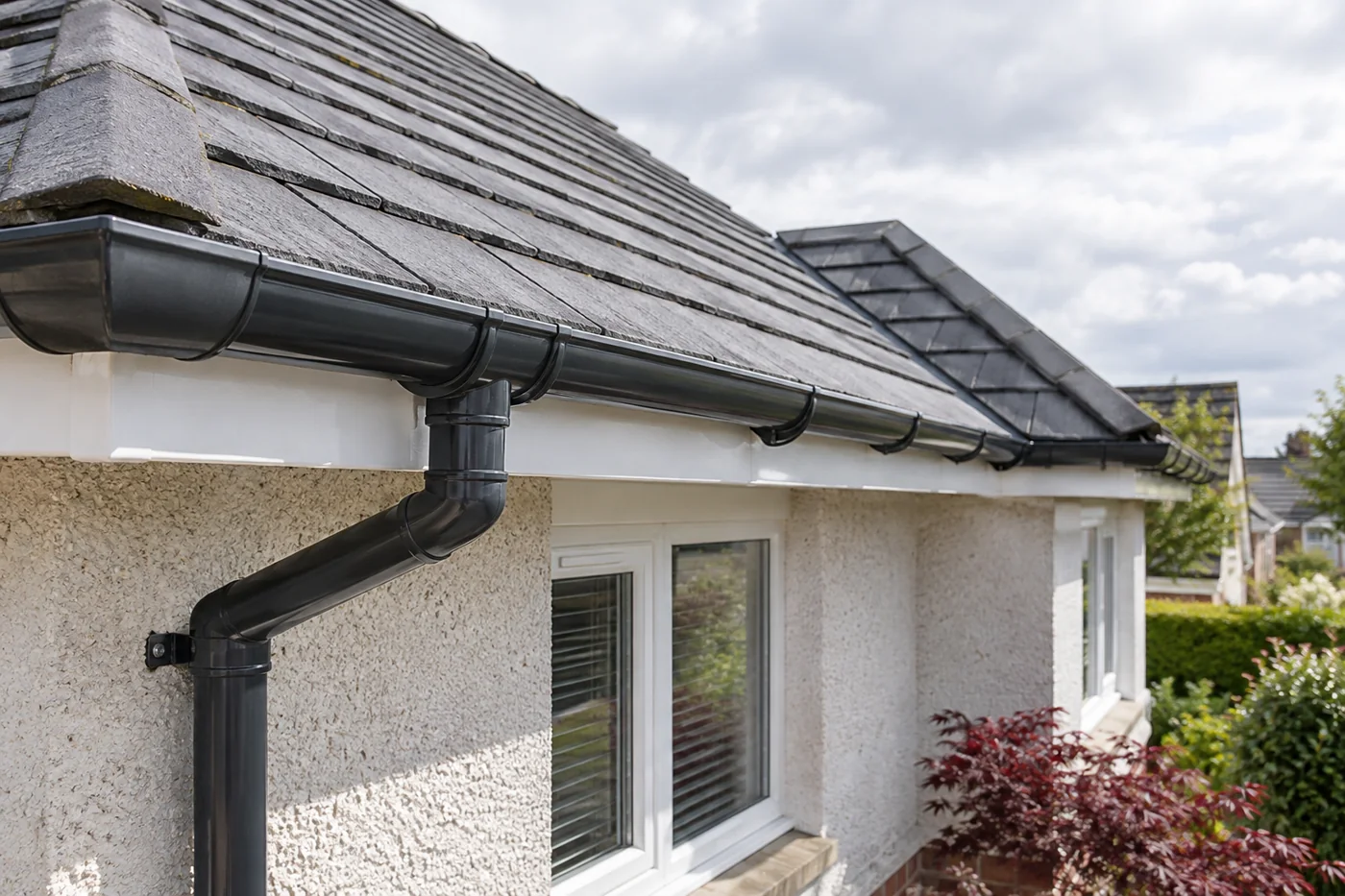 Guttering, fascia and downpipe beneath domestic roof eaves