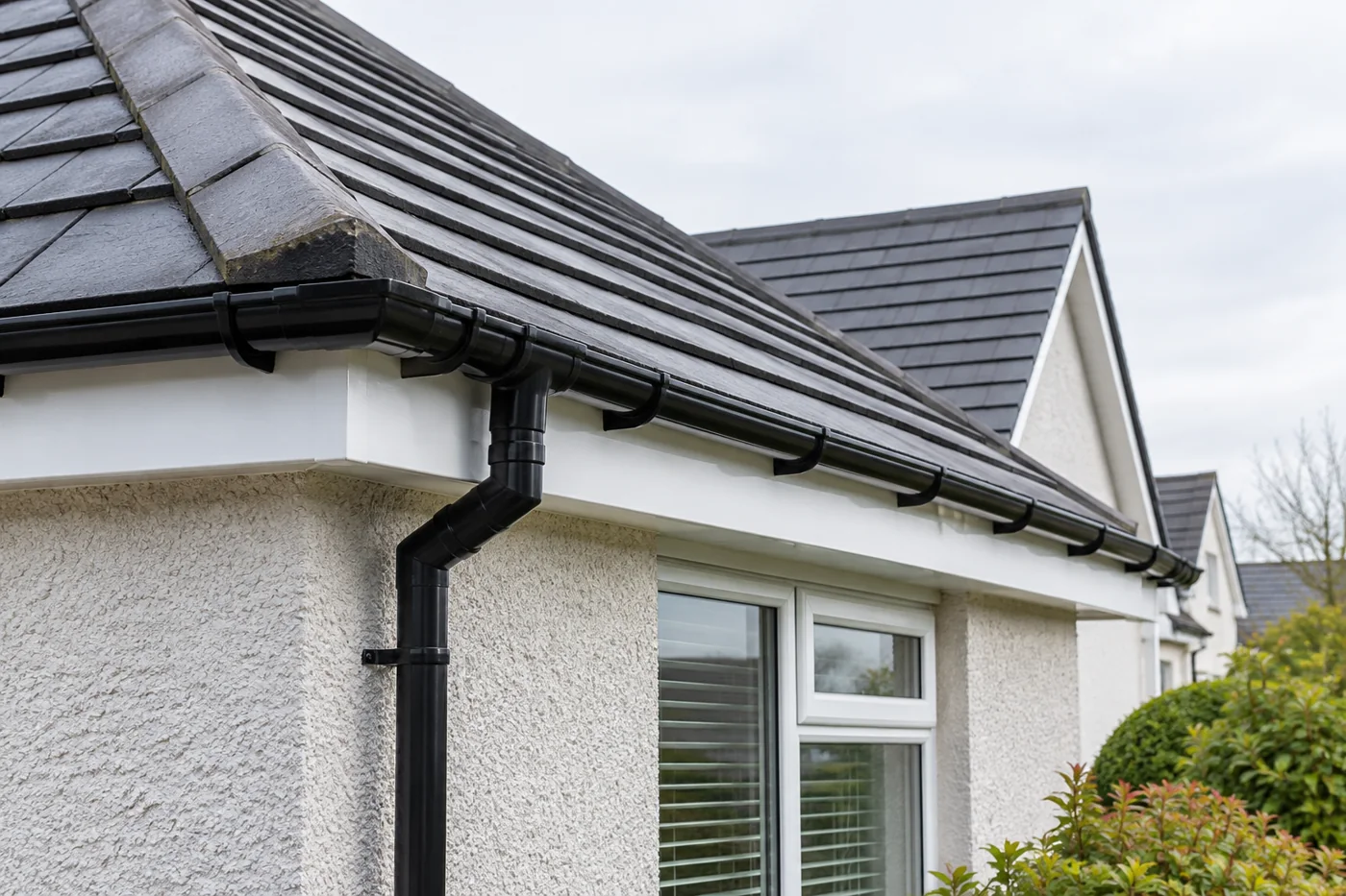Guttering, fascia and downpipe beneath domestic roof eaves